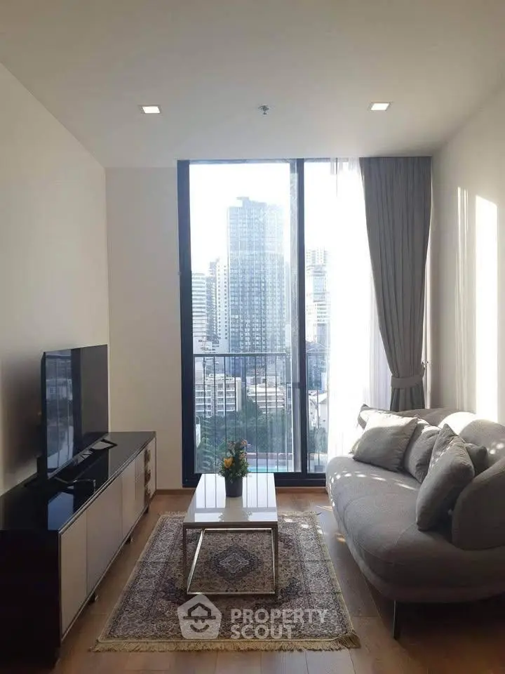 Modern living room with large window offering stunning city view, elegant furniture, and stylish decor.
