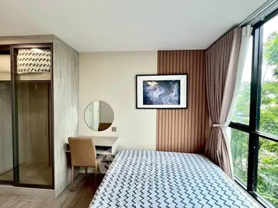 Modern bedroom with large windows and stylish decor in a contemporary apartment.