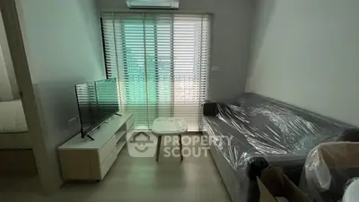 Modern living room with sleek TV setup and cozy couch in a bright apartment.