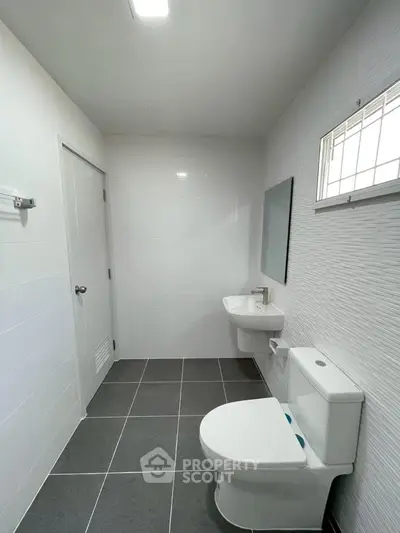 Modern minimalist bathroom with sleek fixtures and tiled flooring