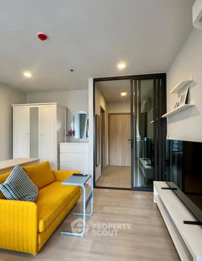 Modern living room with yellow sofa and sleek decor in stylish apartment.