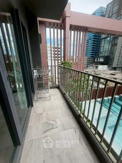 Modern balcony with city view and pool, featuring sleek railing and stylish flooring.