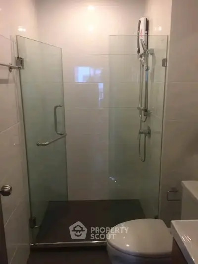 Modern bathroom with glass shower enclosure and sleek fixtures.