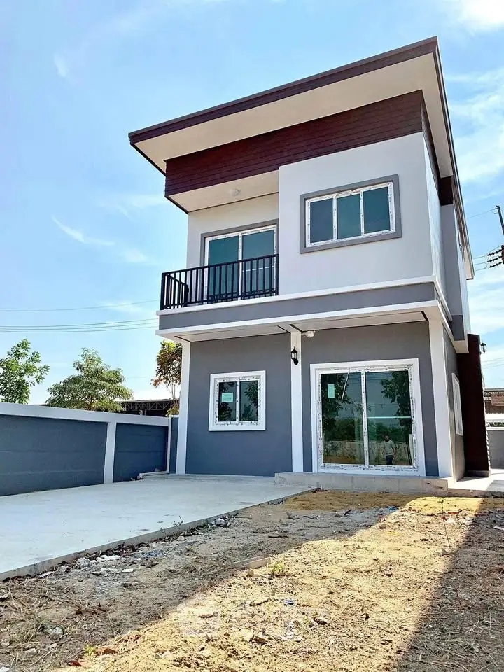 Modern two-story house with sleek design and spacious outdoor area.