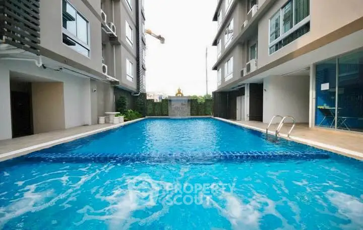 Luxurious apartment complex with a sparkling outdoor pool and modern architecture.