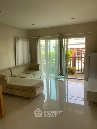 Spacious living room with modern sofa and large windows overlooking garden