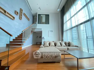 Luxurious modern living room with high ceilings and elegant staircase