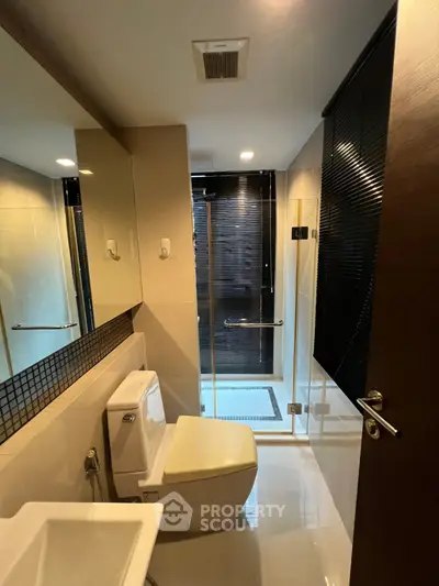 Modern bathroom with sleek design, glass shower, and elegant fixtures in a contemporary apartment.