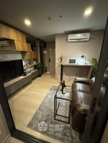 Modern living room with sleek furniture and ambient lighting, featuring a cozy leather sofa and stylish decor.