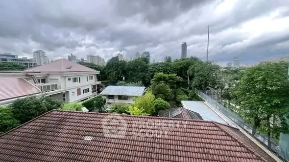 Stunning cityscape view from a residential rooftop with lush greenery and skyline backdrop.