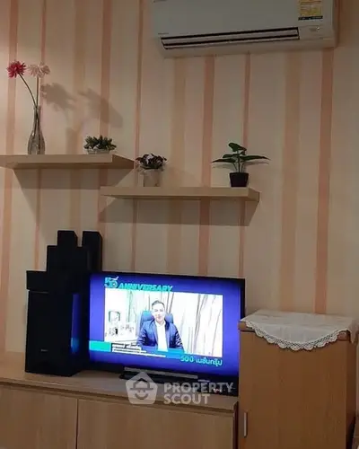 Cozy living room with modern TV setup and air conditioning