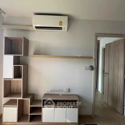 Modern minimalist living room with air conditioning and wooden shelving unit.
