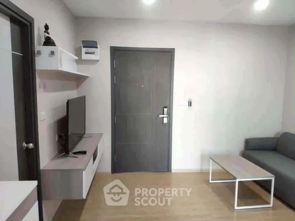 Modern living room with sleek furniture and minimalist decor, featuring a wall-mounted TV and stylish coffee table.