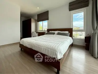 Spacious modern bedroom with large windows and elegant wooden flooring