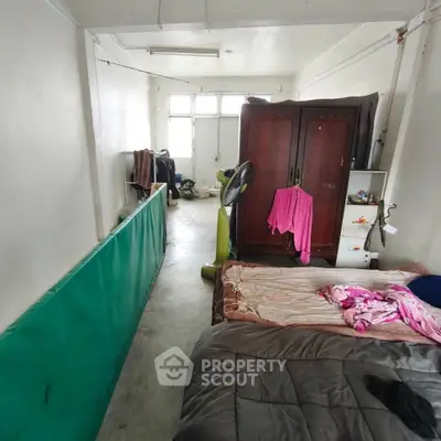 Cozy bedroom with wardrobe and fan, minimalist design, natural light from windows.