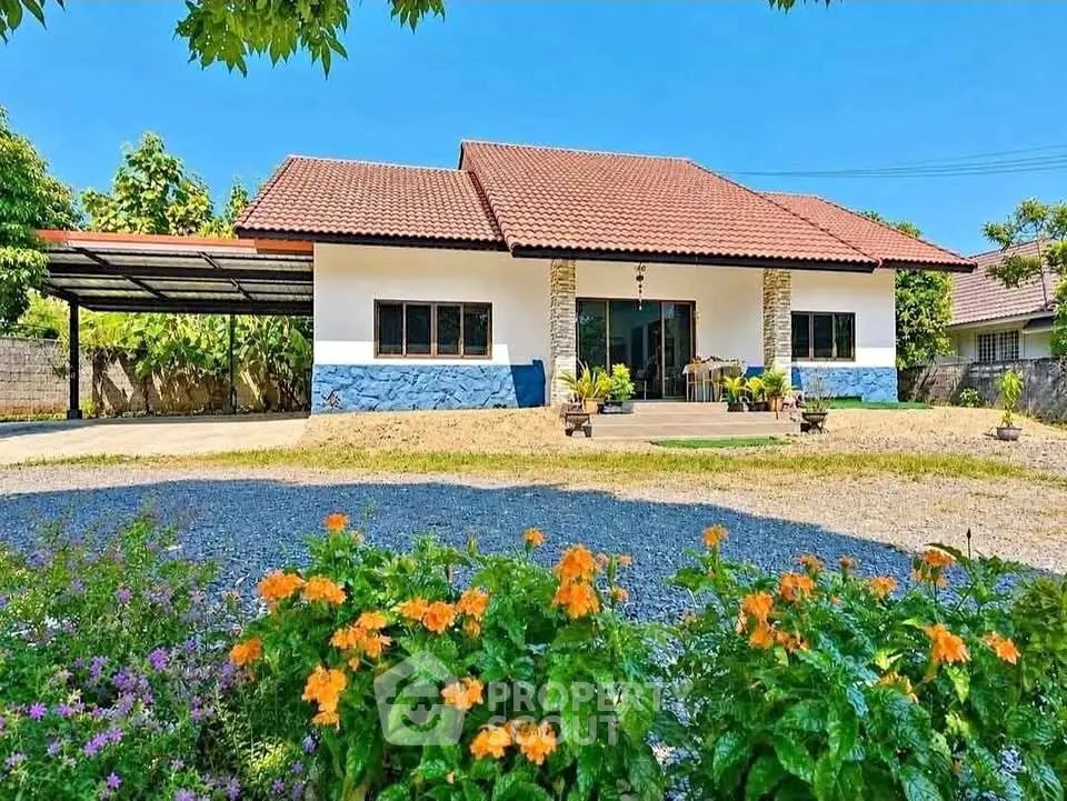 Charming single-story home with red-tiled roof and lush garden in a serene neighborhood.