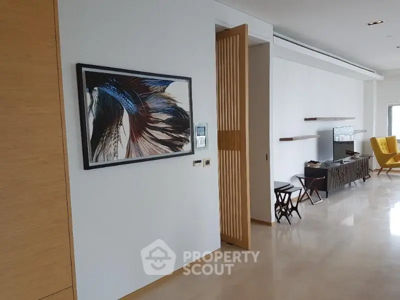 Modern living room with stylish decor and open layout, featuring elegant artwork and sleek furniture.