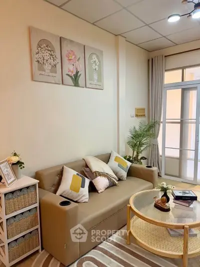 Cozy living room with beige sofa, decorative pillows, and elegant wall art.