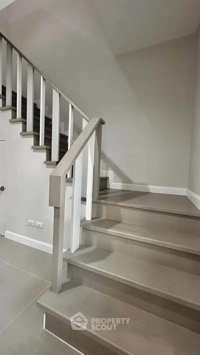 Modern staircase with sleek design and neutral tones in a contemporary home interior.