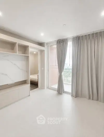 Spacious modern living room with large windows and elegant curtains, offering a bright and airy atmosphere.