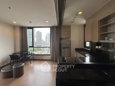 Modern open-layout kitchen with city view, sleek countertops, and dining area in high-rise apartment.