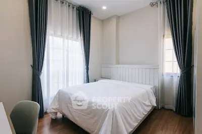 Cozy bedroom with elegant curtains and natural light, perfect for relaxation.