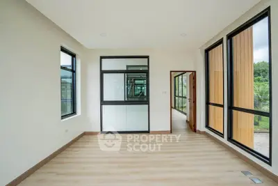 Spacious modern room with large windows and wooden flooring