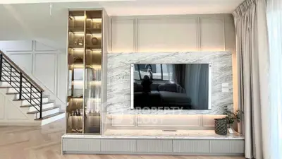 Luxurious living room with marble TV wall and elegant staircase