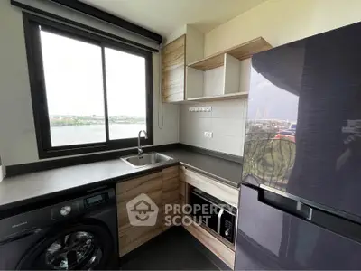 Modern kitchen with sleek appliances and large window offering a scenic view, perfect for culinary enthusiasts.
