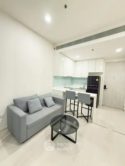 Modern open-layout living room with sleek kitchen and stylish furniture in a contemporary apartment.