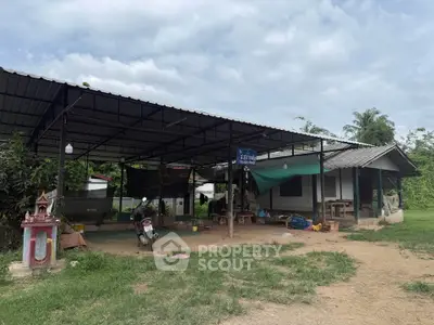 Charming rural property with open-air structure and lush greenery, perfect for serene living or creative projects.