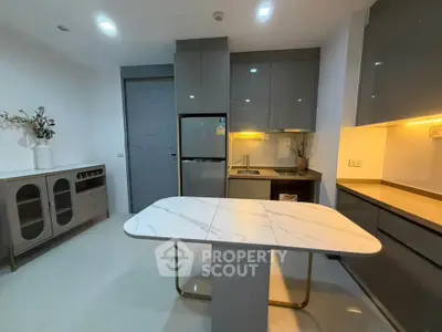Modern kitchen with sleek cabinetry and marble island in contemporary apartment