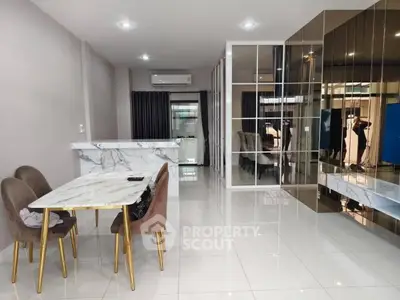 Modern dining area with marble table and gold accents in open layout