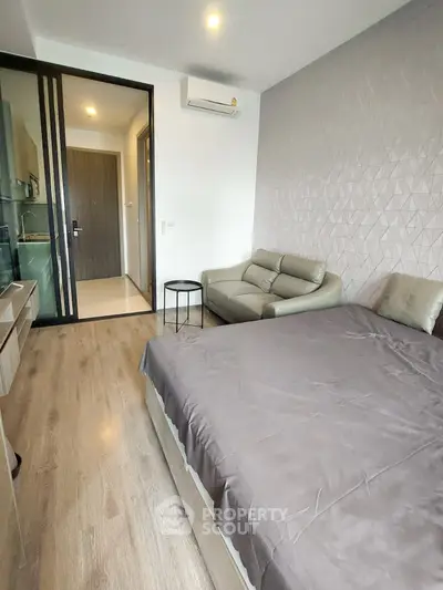 Modern bedroom with stylish decor and cozy seating area in a contemporary apartment.