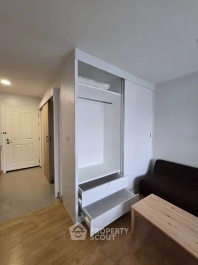 Modern apartment interior with open closet and cozy living area