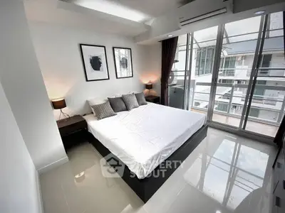 Modern bedroom with large windows and sleek design in a contemporary apartment.