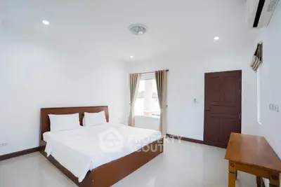 Spacious bedroom with minimalist decor and natural light