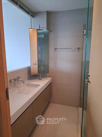Modern bathroom with sleek vanity and glass shower enclosure