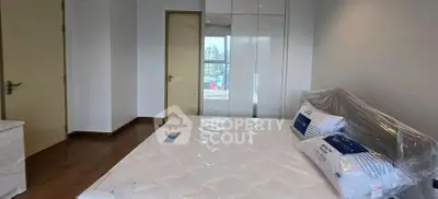 Spacious bedroom with city view, featuring a large bed and modern wardrobe, perfect for urban living.