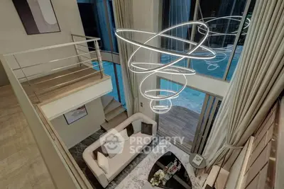 Luxurious modern living room with high ceilings and stunning chandelier overlooking a pool view.