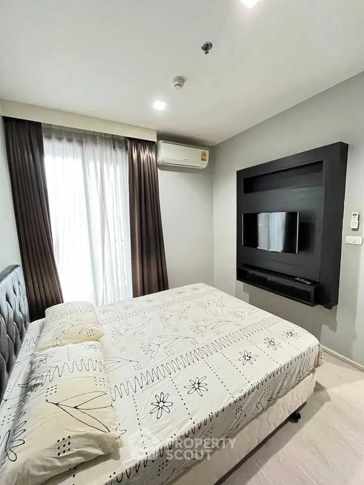 Modern bedroom with stylish decor and wall-mounted TV in a cozy apartment.