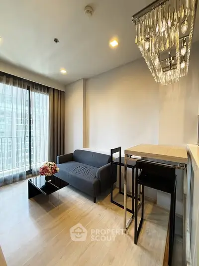Modern living room with elegant chandelier and floor-to-ceiling windows