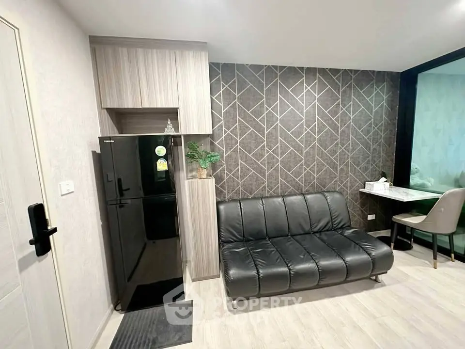 Modern living room with sleek black sofa and stylish geometric accent wall