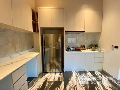 Modern kitchen with sleek cabinetry and stainless steel fridge