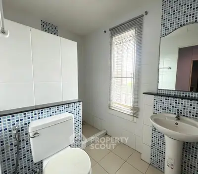 Modern bathroom with stylish mosaic tiles and natural light