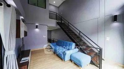 Modern living room with high ceiling and stylish staircase in a contemporary home.
