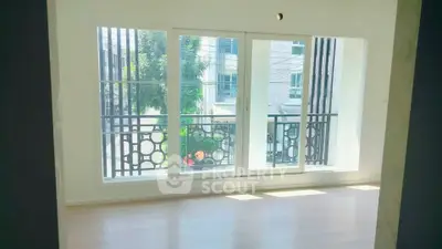 Bright empty room with large windows and balcony view in modern apartment.