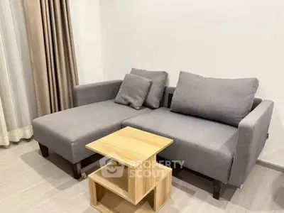 Modern living room with stylish gray sofa and wooden side table