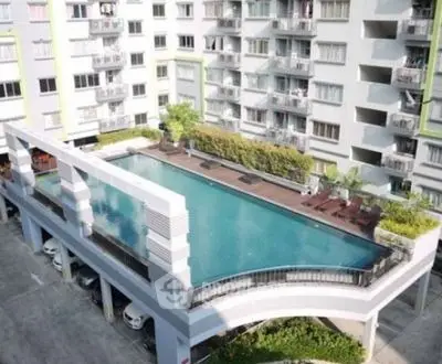 Modern apartment building with rooftop pool and parking area