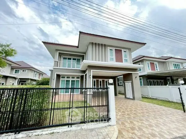 Modern two-story house with spacious driveway and well-maintained lawn.